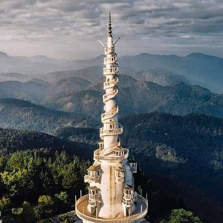 a tower with spiral staircases and trees in the background